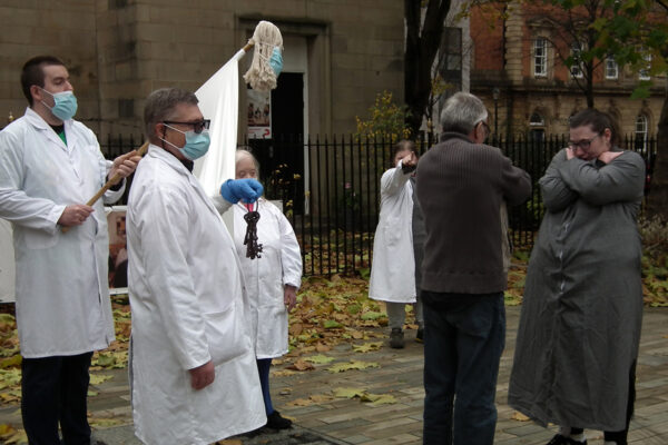 A scene in front of St Phillip's church. Two patients were dancing together but have been stopped by the doctors.