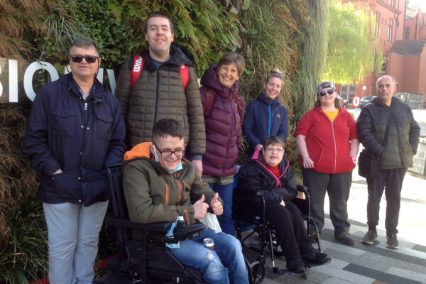 Photo of our time with the Environmental Sustainability Team at University of Salford - DIY members are standing infront of a green wall full of plants