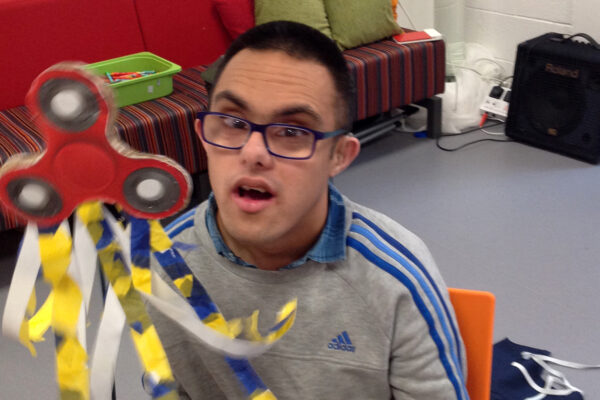 photo of student with a colourful puppet that he has made as part of his Explore Arts Award.