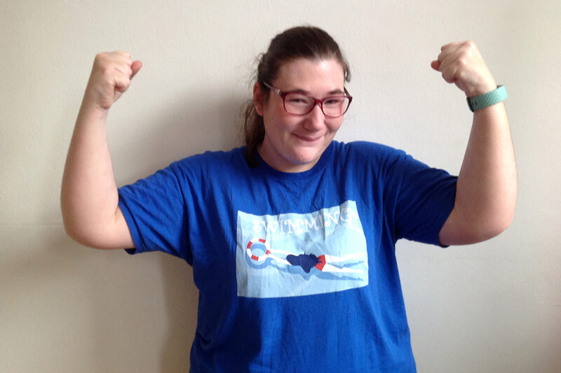 photo young woman standing like a boxer when they win with fists held high on either side of her head. She looks happy! 